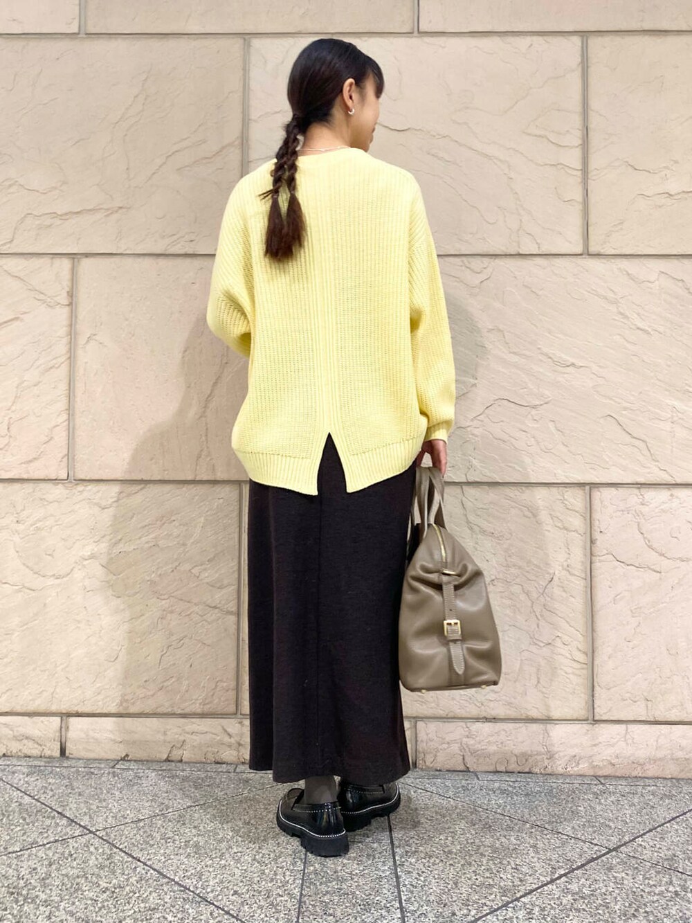 ベージュ系のボストンバッグ、グレー系のスカート、イエロー系のニット/セーターを着用したレディースの冬コーディネートの4枚目の写真