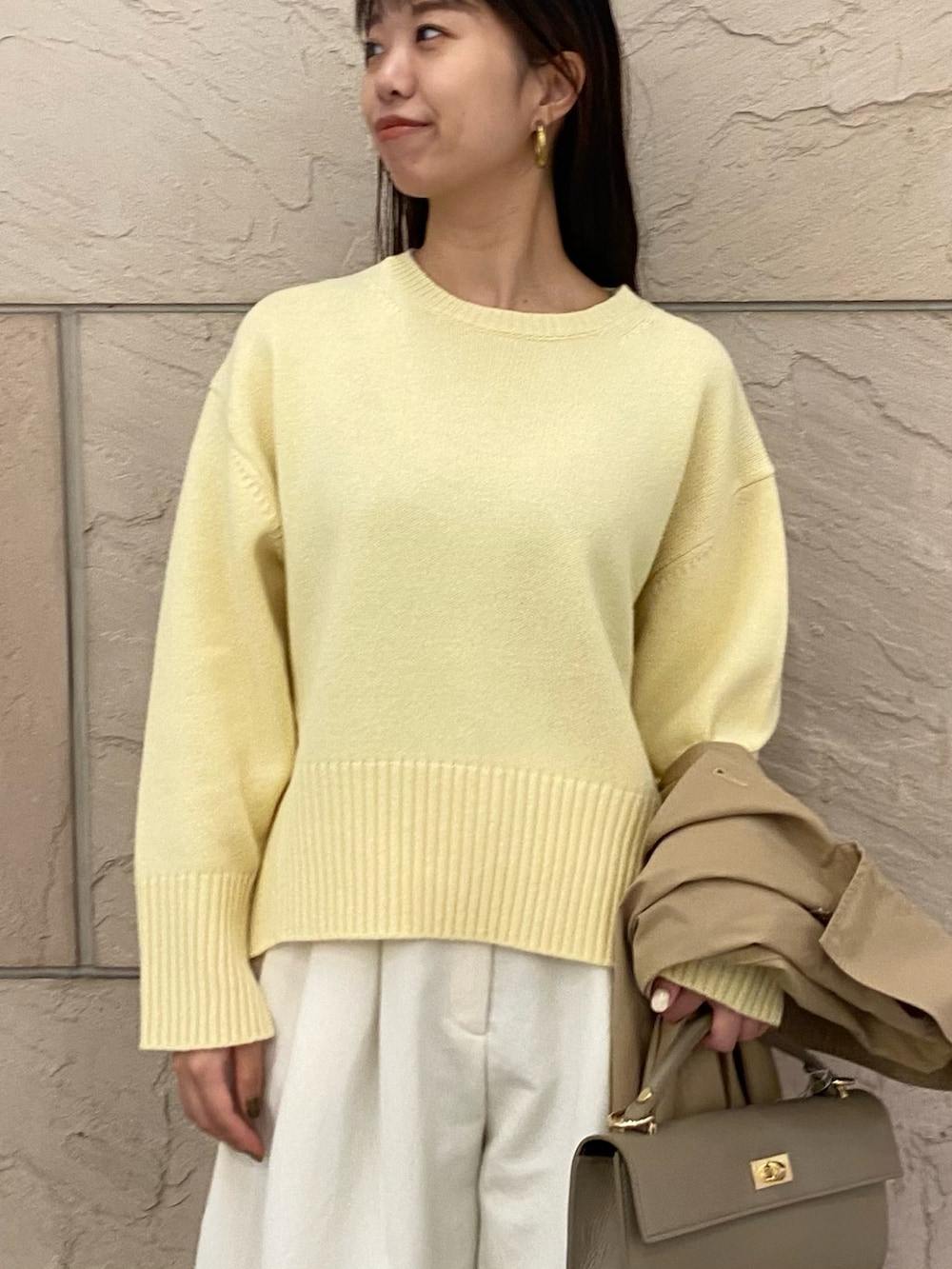 イエロー系のニット/セーター、イエロー系のニット/セーター、ベージュ系のその他アウターを着用したレディースの秋コーディネートの8枚目の写真