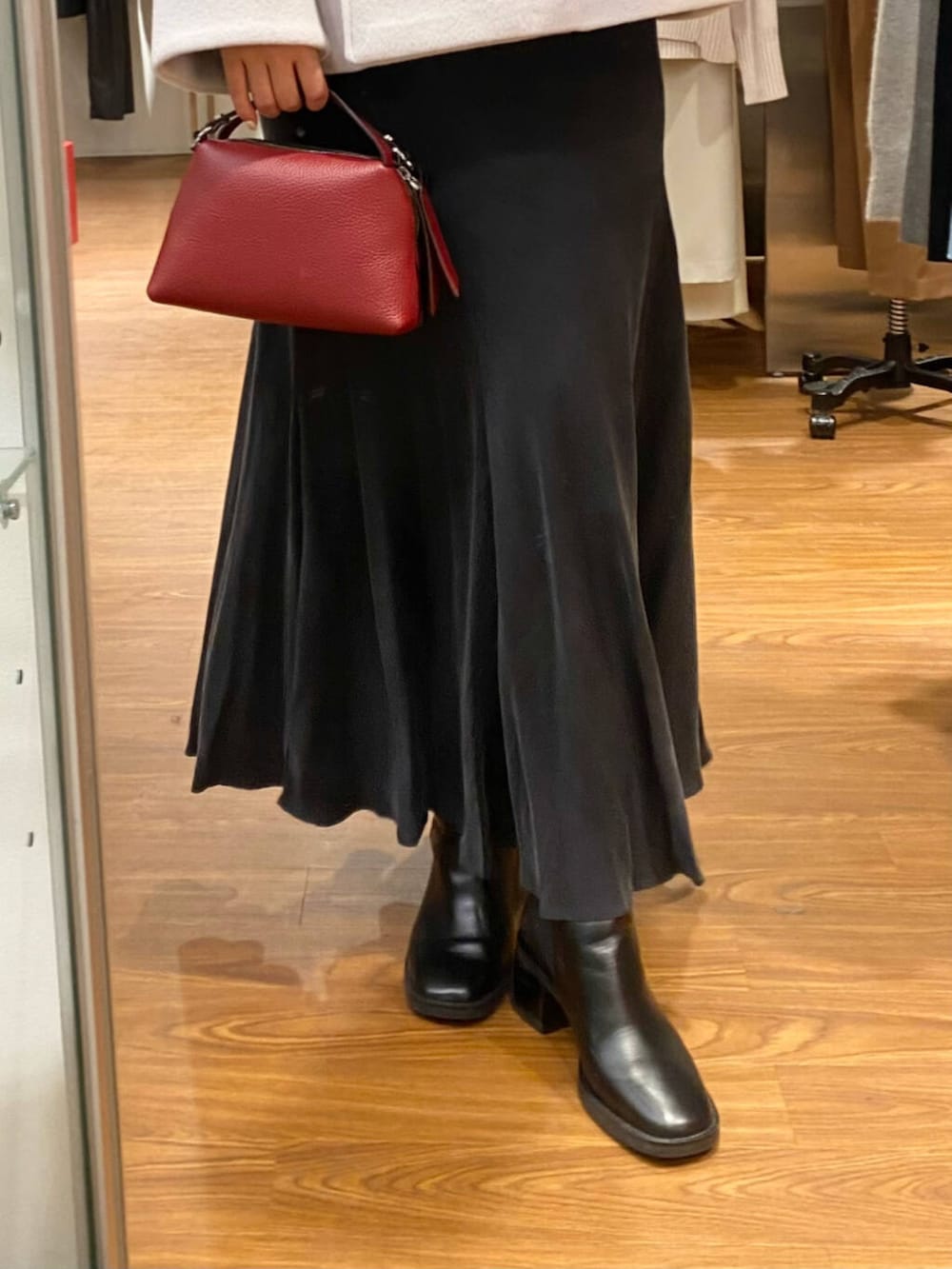 グレー系のピーコート、ブラック系のブーツ、グレー系のスカートを着用したレディースの秋コーディネートの7枚目の写真