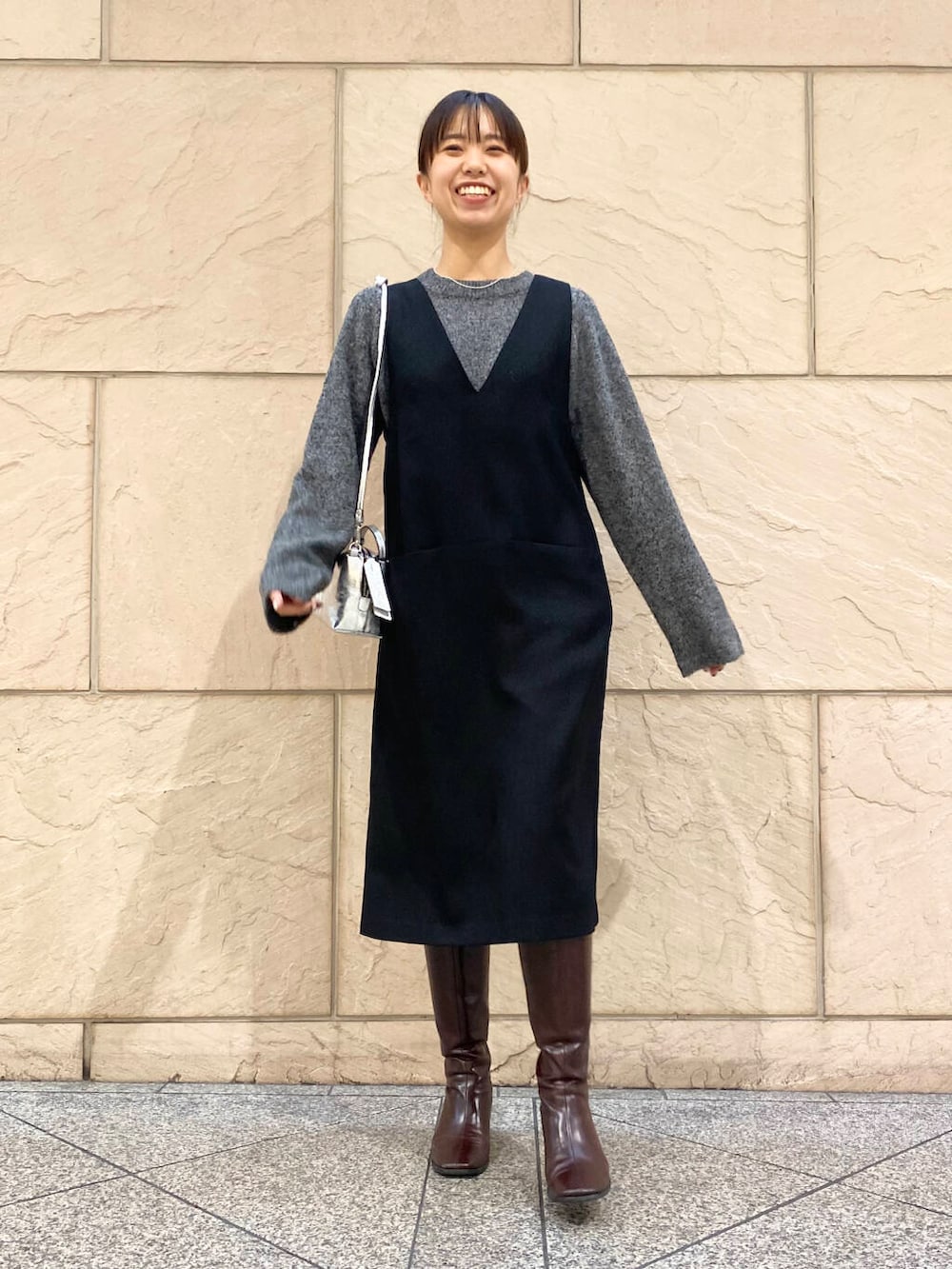 レッド系のブーツ、ブラック系のワンピース、グレー系のニット/セーターを着用したレディースの冬コーディネートの6枚目の写真