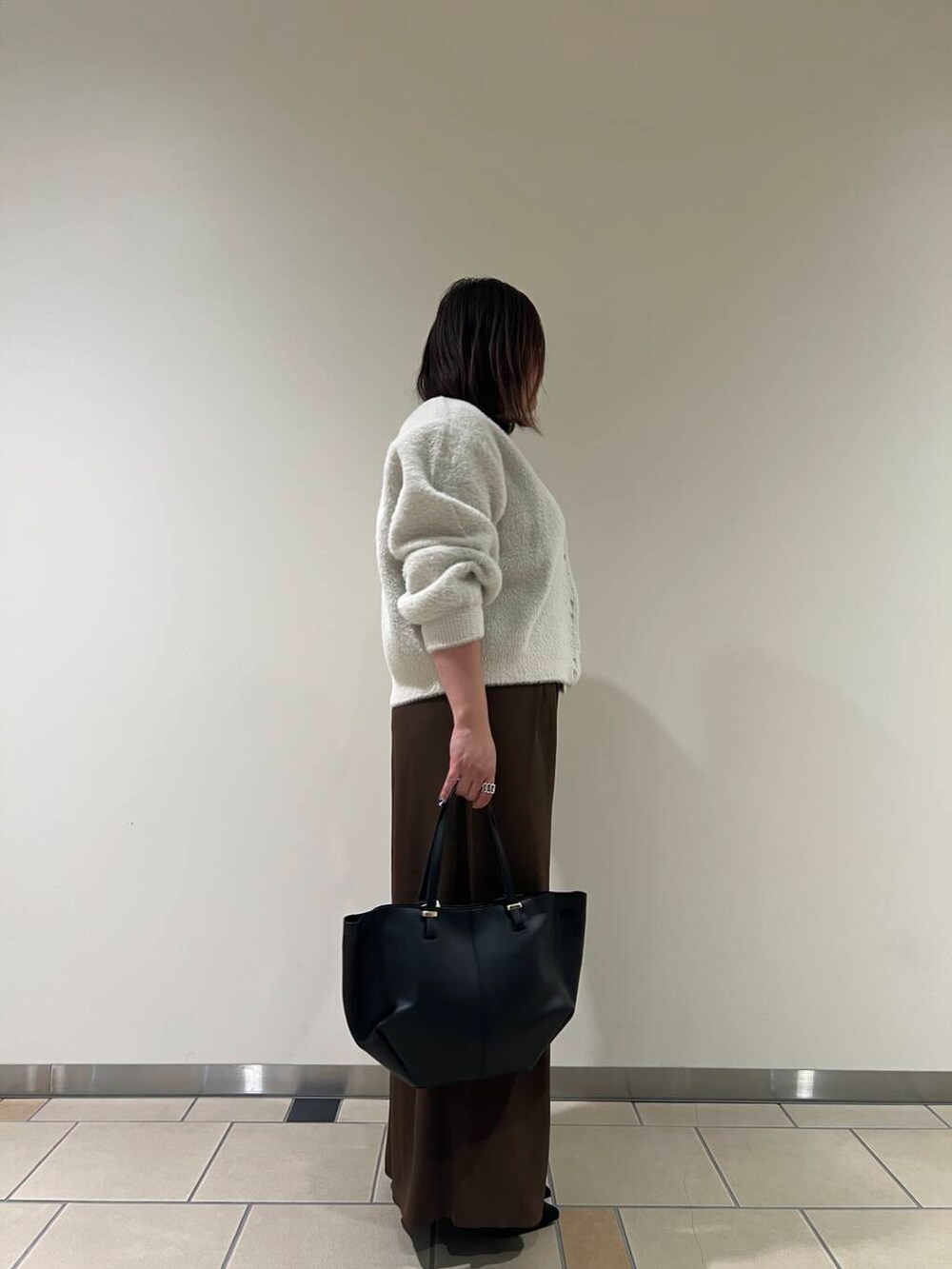 ブラック系のパンプス、ブラック系のショルダーバッグ、ブラック系のタンクトップを着用したレディースの秋コーディネートの4枚目の写真