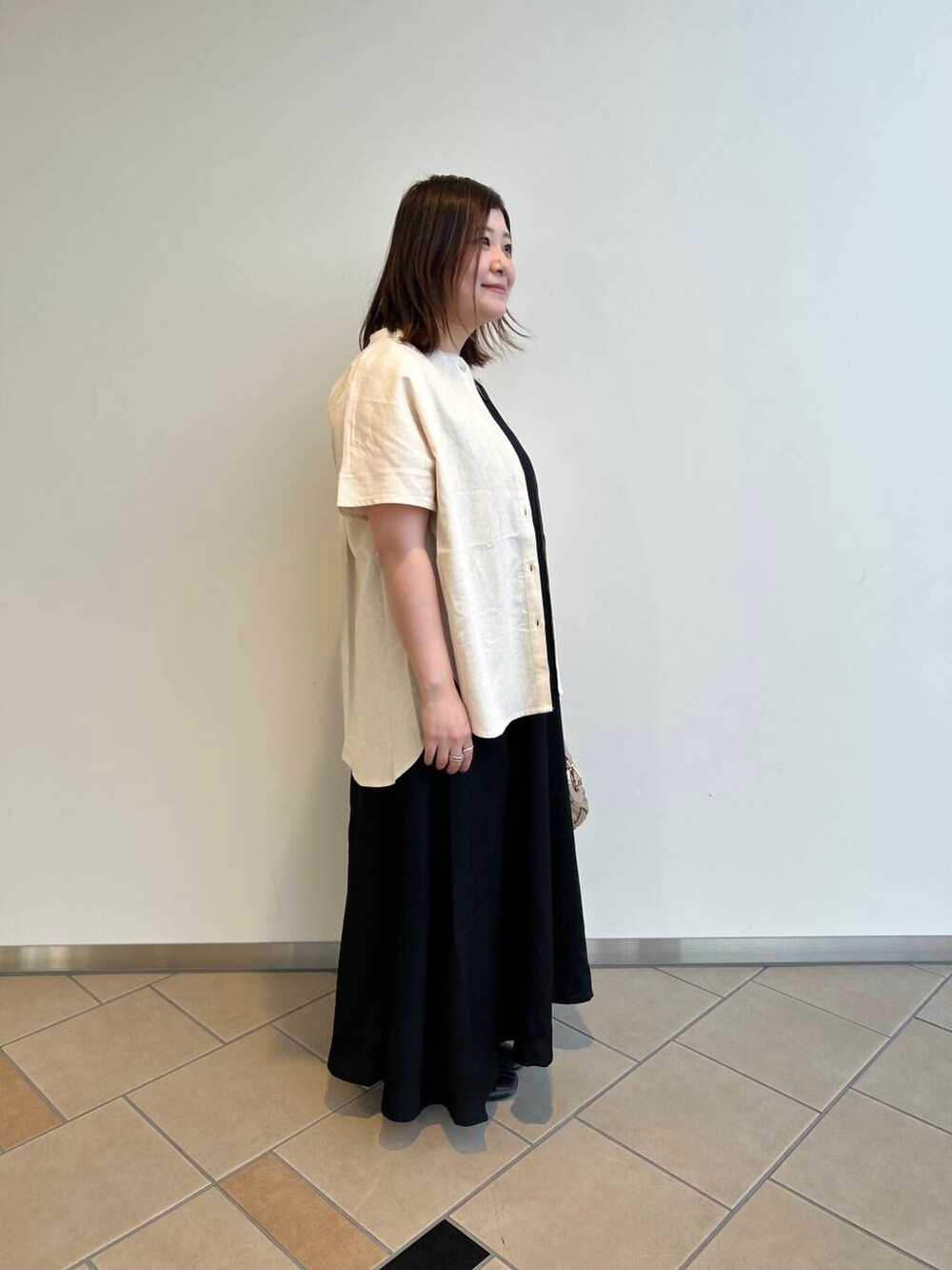 ベージュ系のシャツ/ブラウス、ベージュ系のショルダーバッグ、レッド系のタンクトップを着用したレディースの夏コーディネートの2枚目の写真