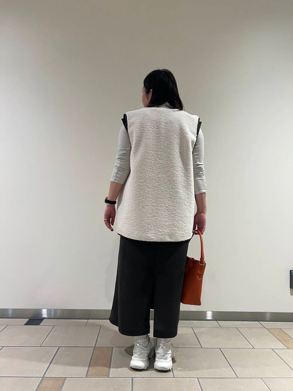 グレー系のTシャツ/カットソー、オレンジ系のハンドバッグ、ホワイト系のその他アウターを着用したレディースの秋コーディネートの3枚目の写真