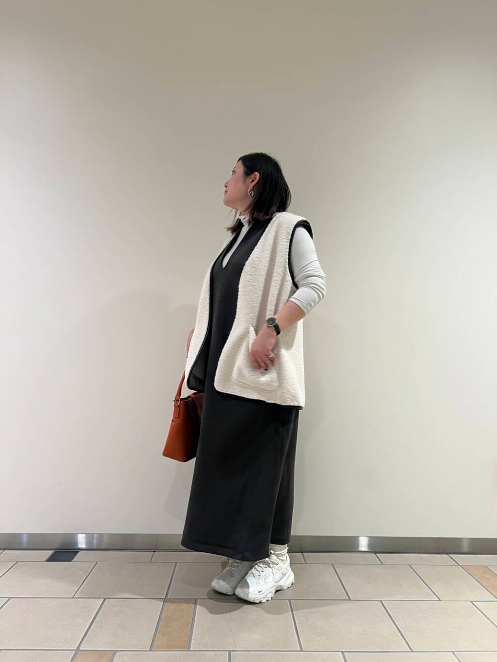 グレー系のTシャツ/カットソー、オレンジ系のハンドバッグ、ホワイト系のその他アウターを着用したレディースの秋コーディネートの4枚目の写真