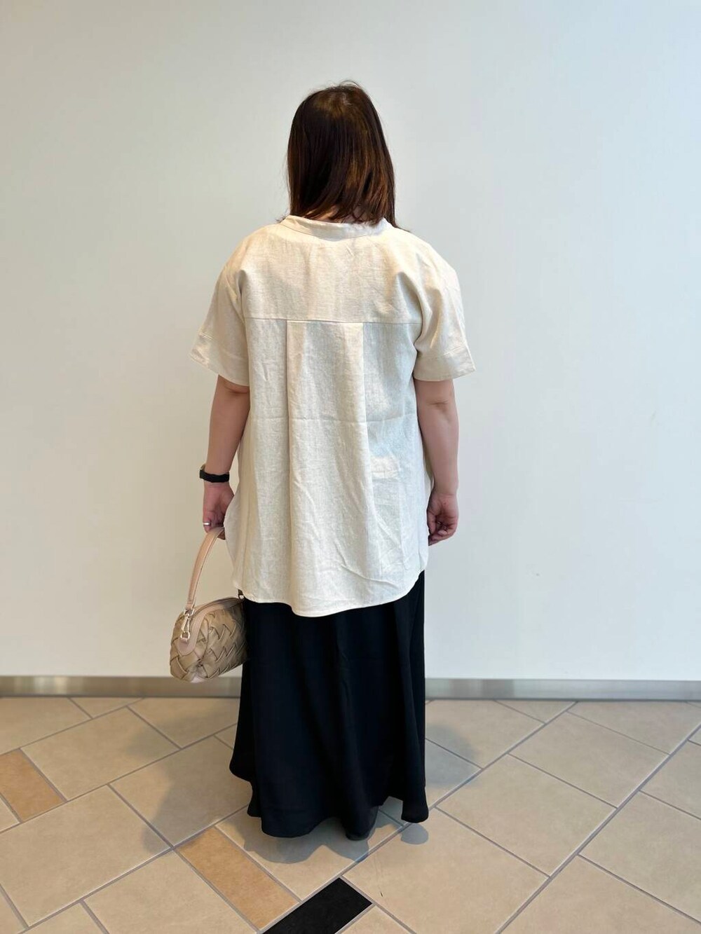 ベージュ系のシャツ/ブラウス、ベージュ系のショルダーバッグ、レッド系のタンクトップを着用したレディースの夏コーディネートの3枚目の写真