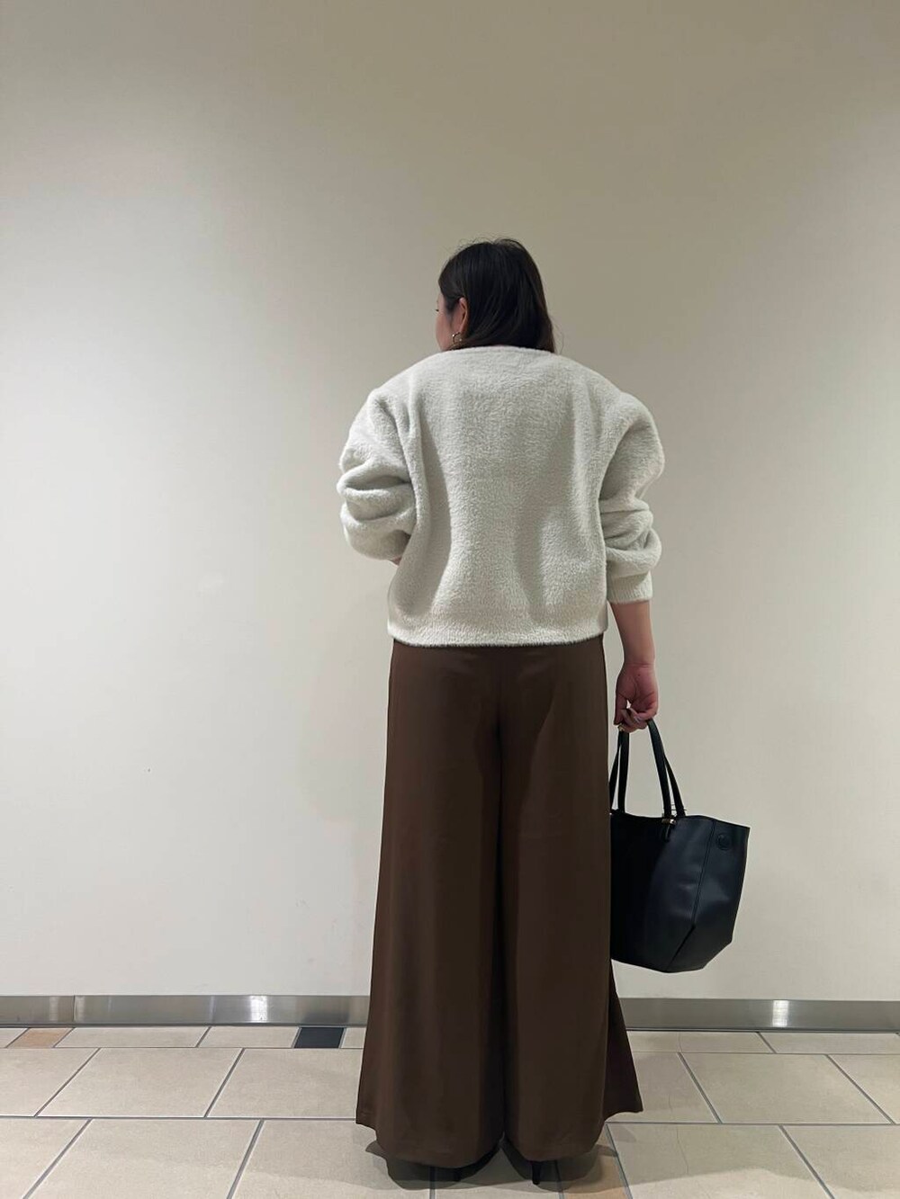 ブラック系のパンプス、ブラック系のショルダーバッグ、ブラック系のタンクトップを着用したレディースの秋コーディネートの3枚目の写真