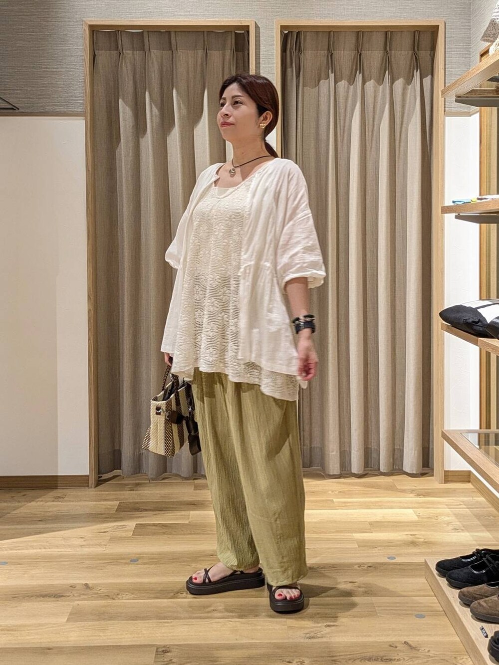 イエロー系のその他パンツ、ブルー系のショルダーバッグ、ブラウン系のサンダルを着用したレディースの夏コーディネートの2枚目の写真