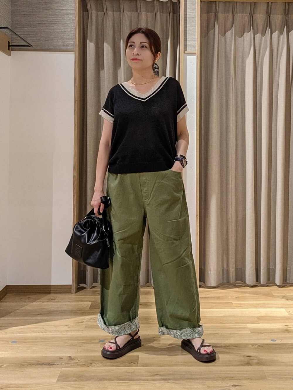グリーン系のデニムパンツ、ブラック系のニット/セーター、ブラウン系のサンダルを着用したレディースの夏コーディネートの4枚目の写真