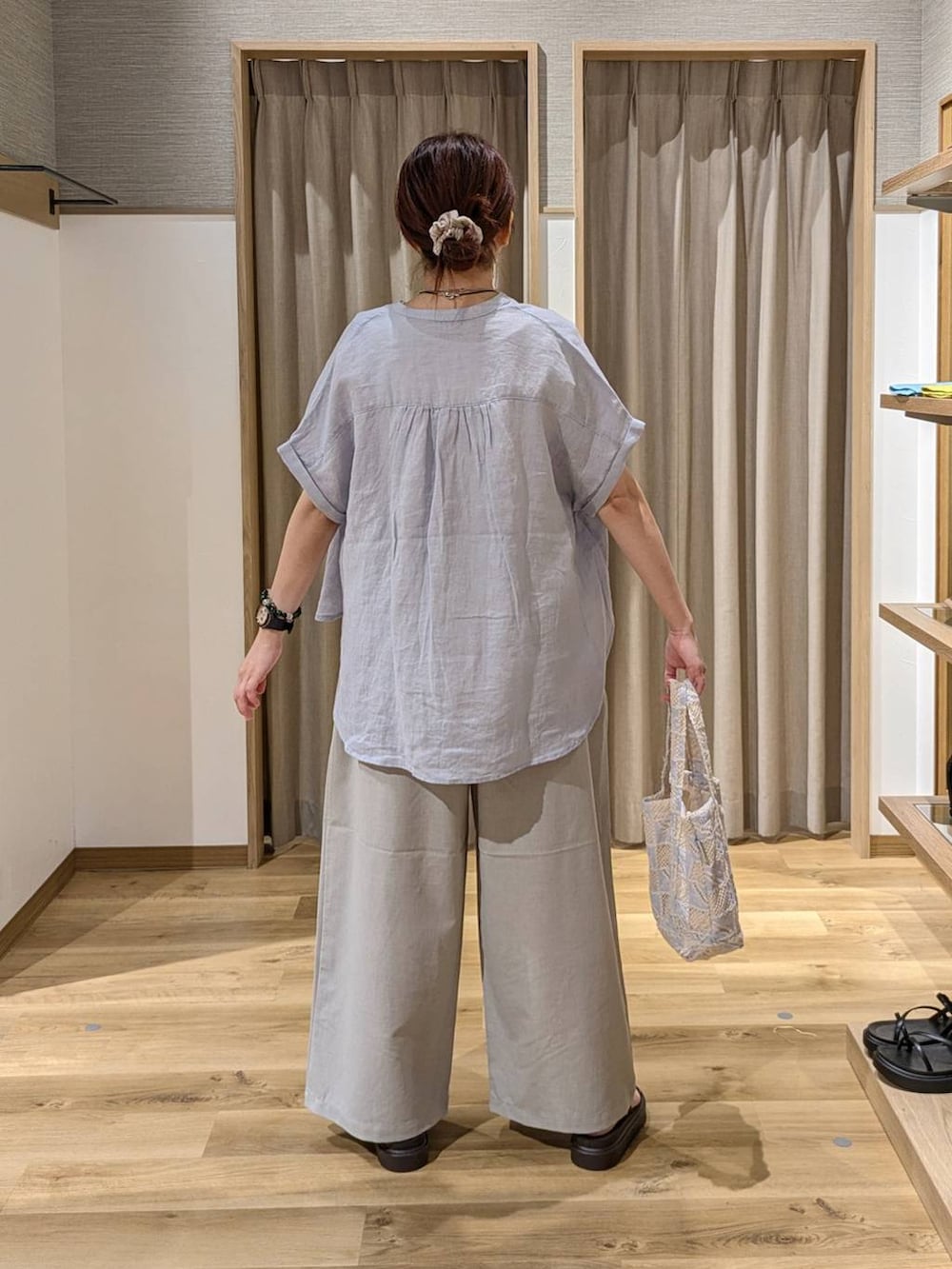 ブルー系のシャツ/ブラウス、ブラウン系のサンダル、ブルー系のトートバッグを着用したレディースの夏コーディネートの2枚目の写真