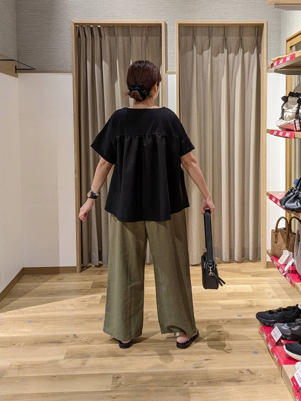 ブラック系のショルダーバッグ、ゴールド系のサンダル、グリーン系のその他パンツを着用したレディースの夏コーディネートの2枚目の写真