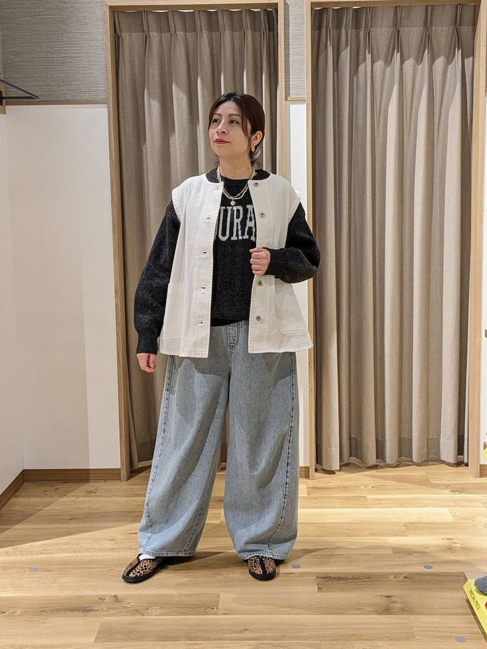 ホワイト系のベスト、グレー系のニット/セーター、その他のスニーカーを着用したレディースの冬コーディネートの2枚目の写真