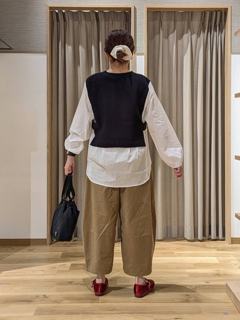 レッド系のその他シューズ、ベージュ系のその他パンツ、ブラック系のショルダーバッグを着用したレディースの秋コーディネートの3枚目の写真