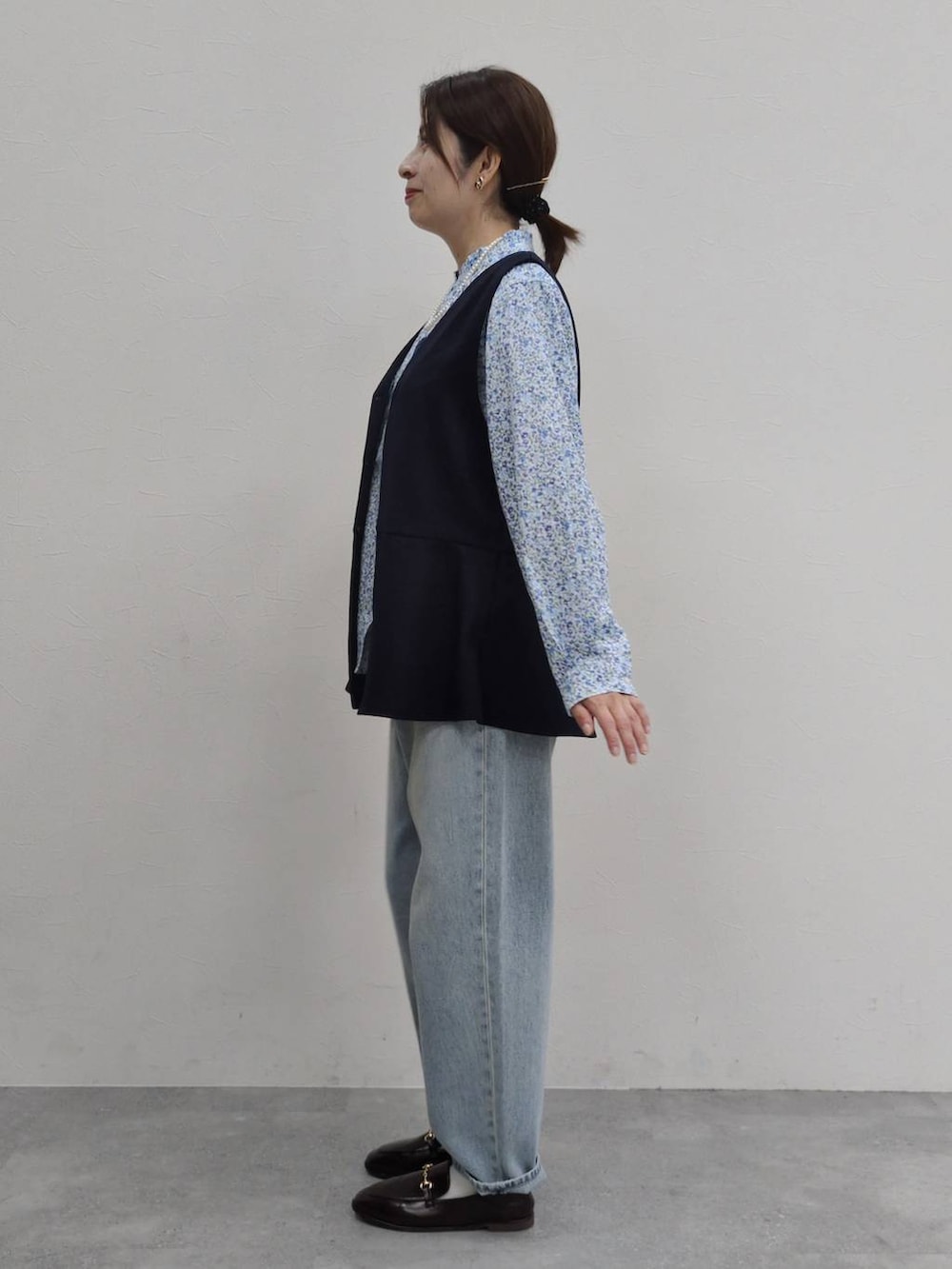 ブルー系のデニムパンツ、ブラック系のスーツセット、ブラウン系のローファーを着用したレディースの冬コーディネートの2枚目の写真