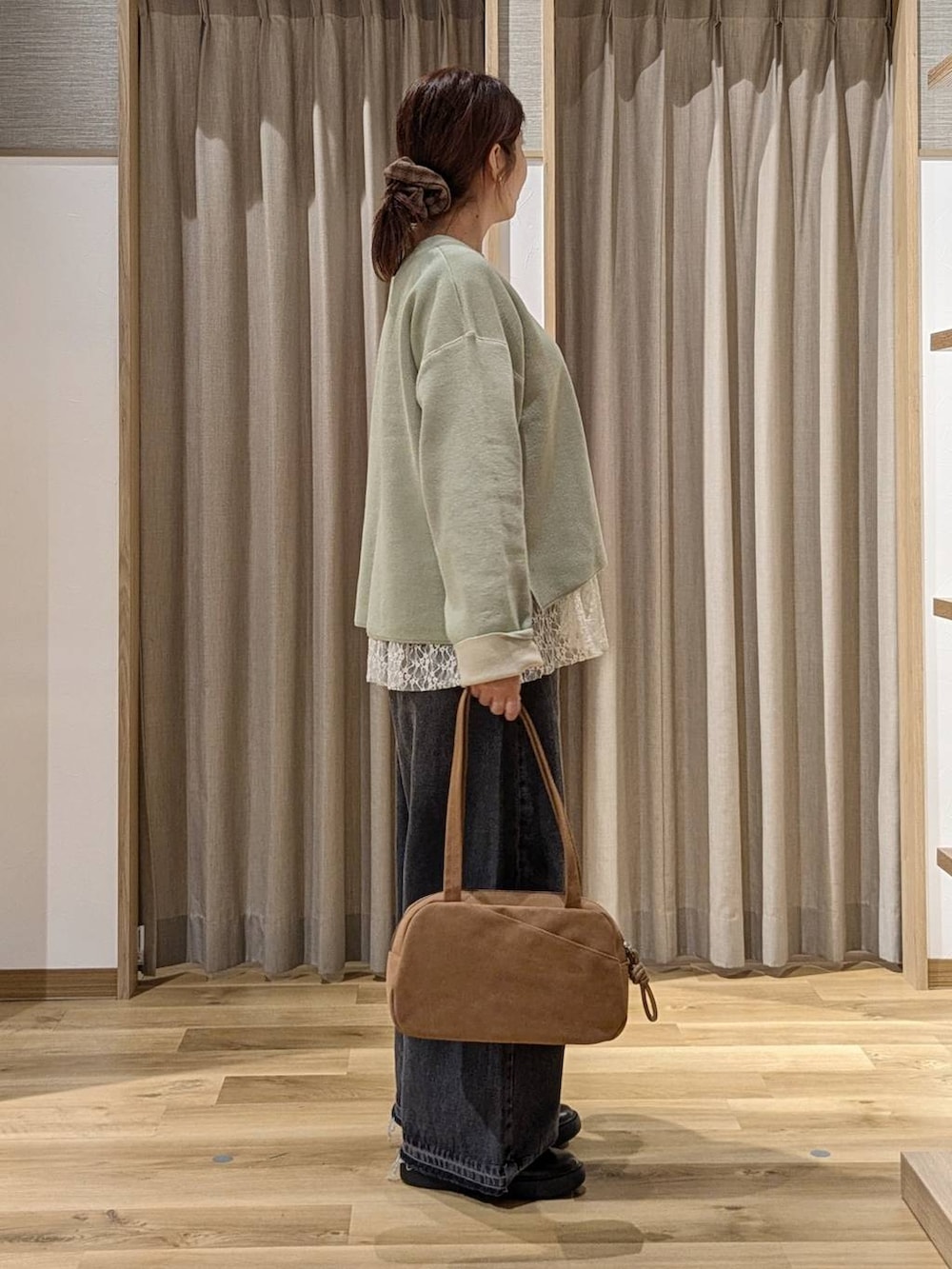 ブラウン系のショルダーバッグ、その他のTシャツ/カットソー、グリーン系のニット/セーターを着用したレディースの秋コーディネートの2枚目の写真