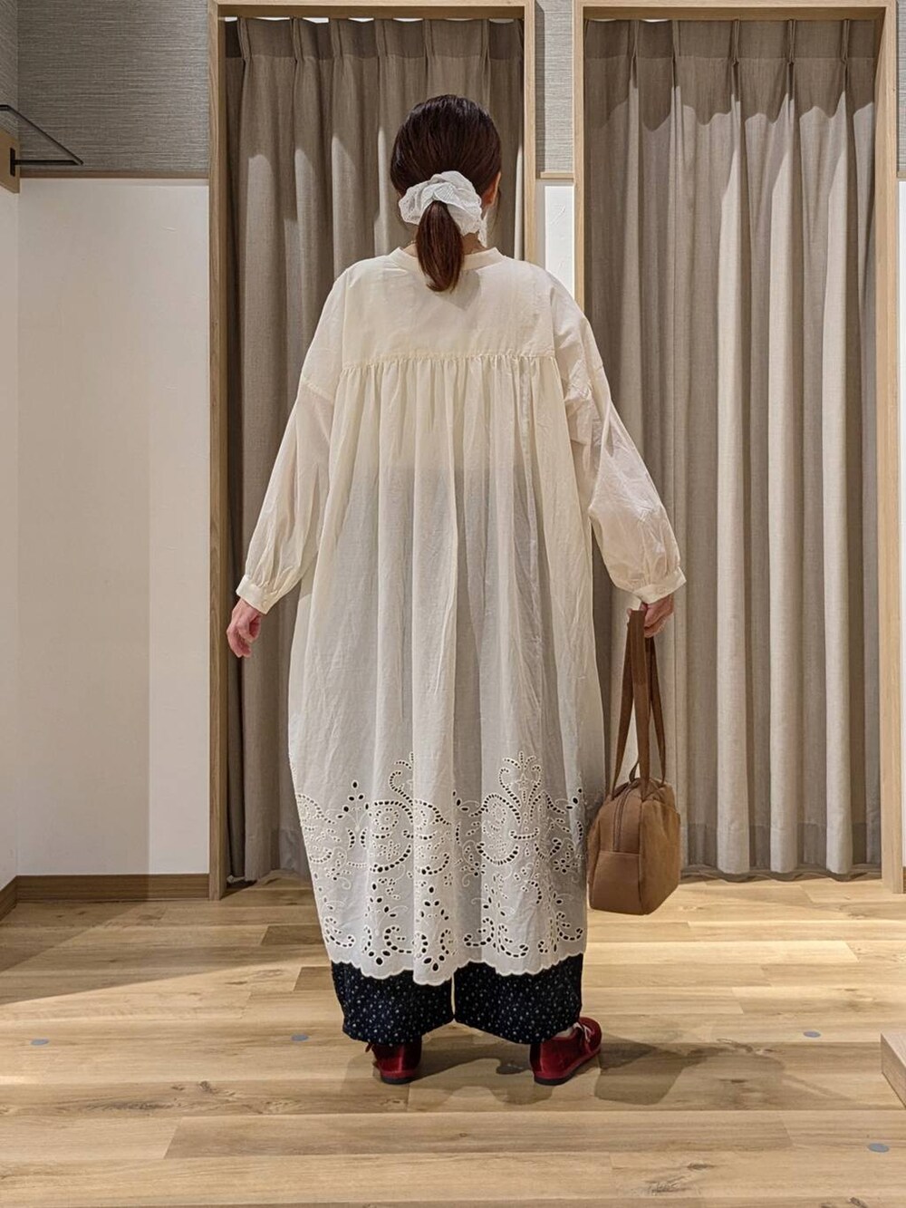 ブラウン系のショルダーバッグ、ブルー系のその他パンツ、レッド系のその他シューズを着用したレディースの秋コーディネートの3枚目の写真