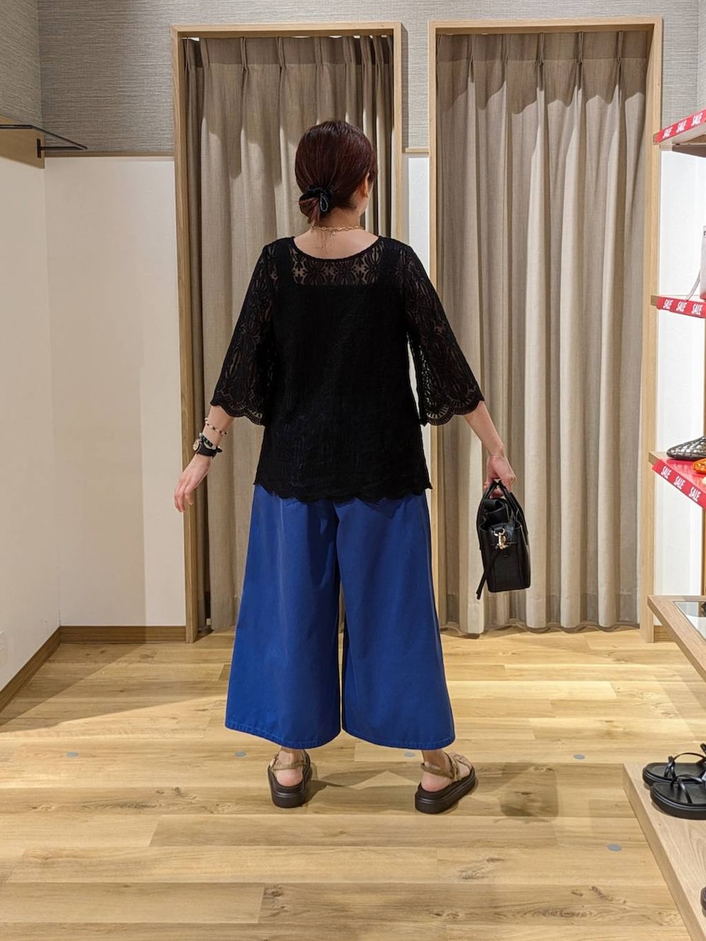 ベージュ系のサンダル、ブラック系のタンクトップ、ブラック系のショルダーバッグを着用したレディースの夏コーディネートの2枚目の写真