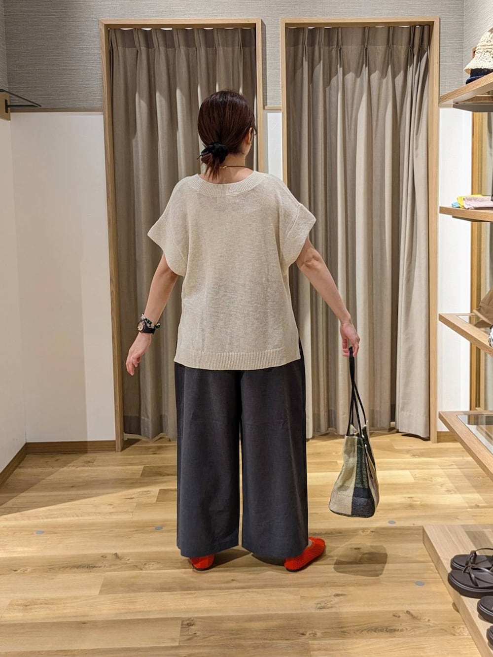 イエロー系のトートバッグ、グレー系のその他パンツ、ベージュ系のベストを着用したレディースの夏コーディネートの2枚目の写真