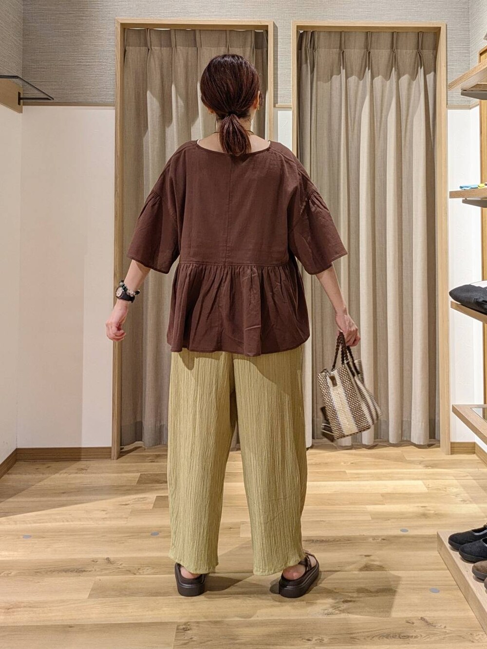 イエロー系のその他パンツ、ブルー系のショルダーバッグ、ブラウン系のサンダルを着用したレディースの夏コーディネートの2枚目の写真