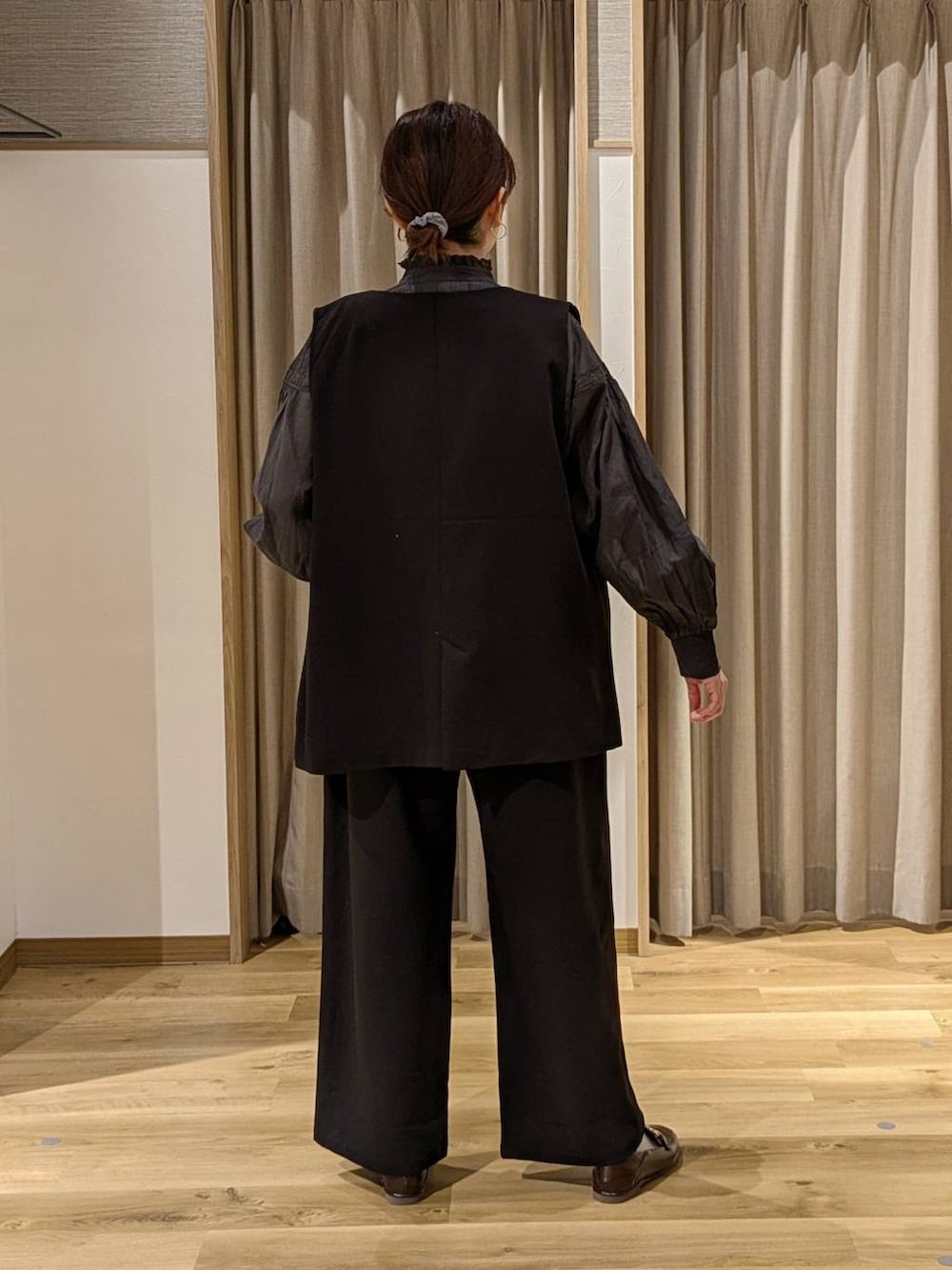 ブラック系のシャツ/ブラウス、ブラック系のベスト、ブラック系のスラックスを着用したレディースの冬コーディネートの2枚目の写真