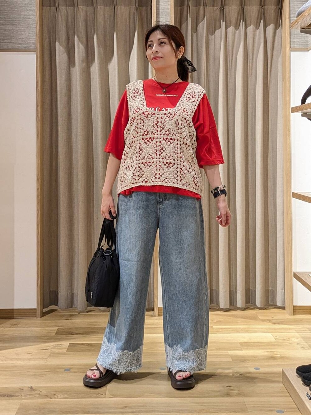 ブルー系のデニムパンツ、レッド系のTシャツ/カットソー、ベージュ系のベストを着用したレディースの夏コーディネートの4枚目の写真