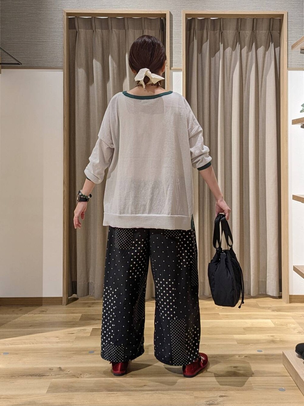レッド系のその他シューズ、グレー系のニット/セーター、ブラック系のその他パンツを着用したレディースの秋コーディネートの3枚目の写真