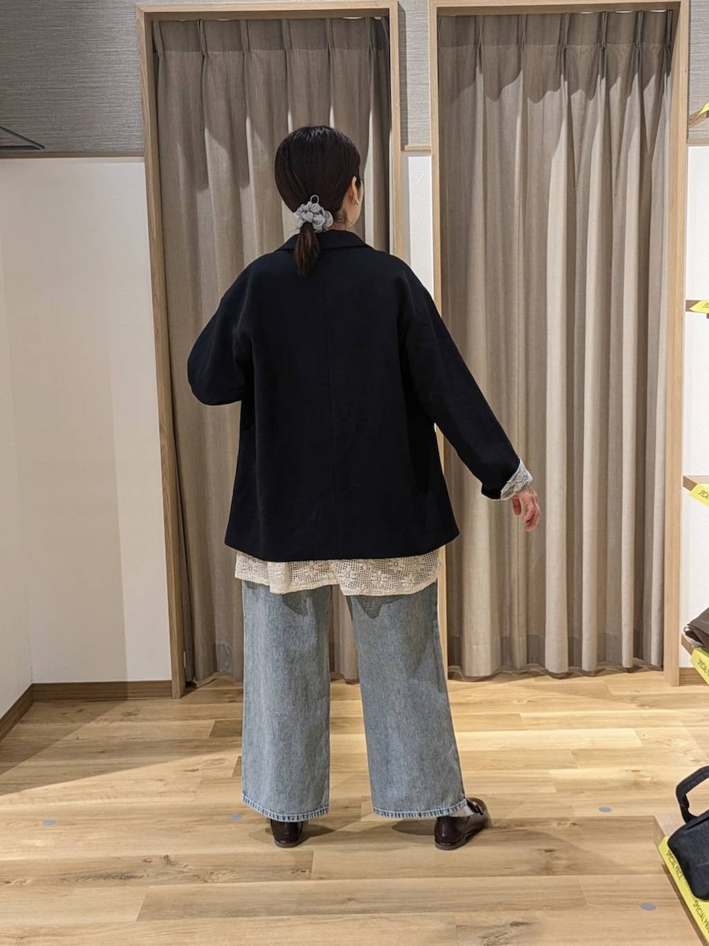 ブルー系のデニムパンツ、ブルー系のテーラードジャケット、ブラウン系のトートバッグを着用したレディースの春コーディネートの2枚目の写真