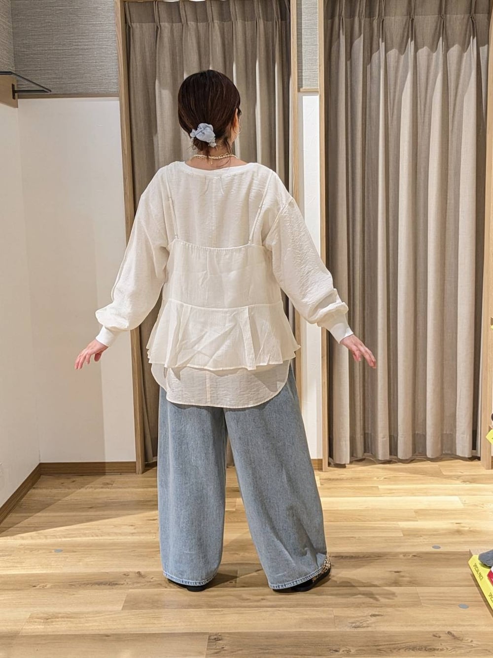 ホワイト系のキャミソール、ブルー系のデニムパンツ、その他のスニーカーを着用したレディースの冬コーディネートの3枚目の写真