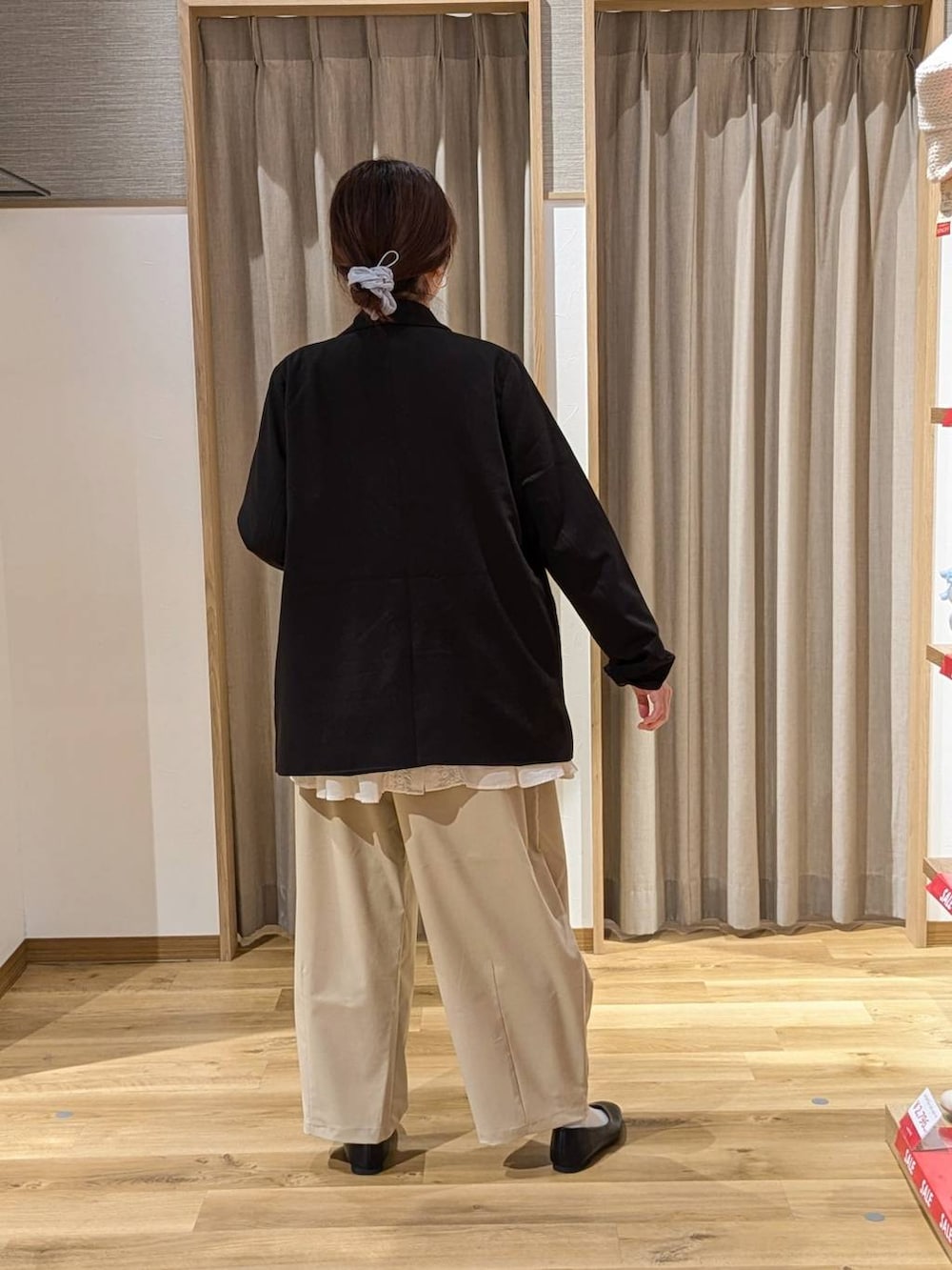 ブラック系のテーラードジャケット、ブラック系のショルダーバッグ、ベージュ系のその他パンツを着用したレディースの冬コーディネートの2枚目の写真