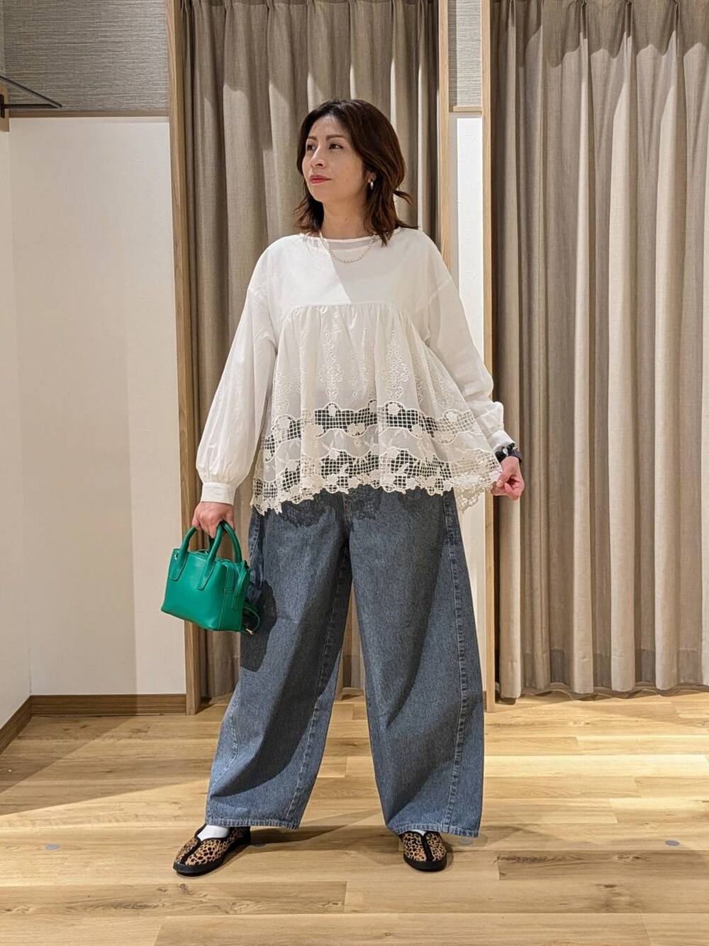 ブルー系のデニムパンツ、その他のスニーカー、グリーン系のトートバッグを着用したレディースの冬コーディネートの2枚目の写真