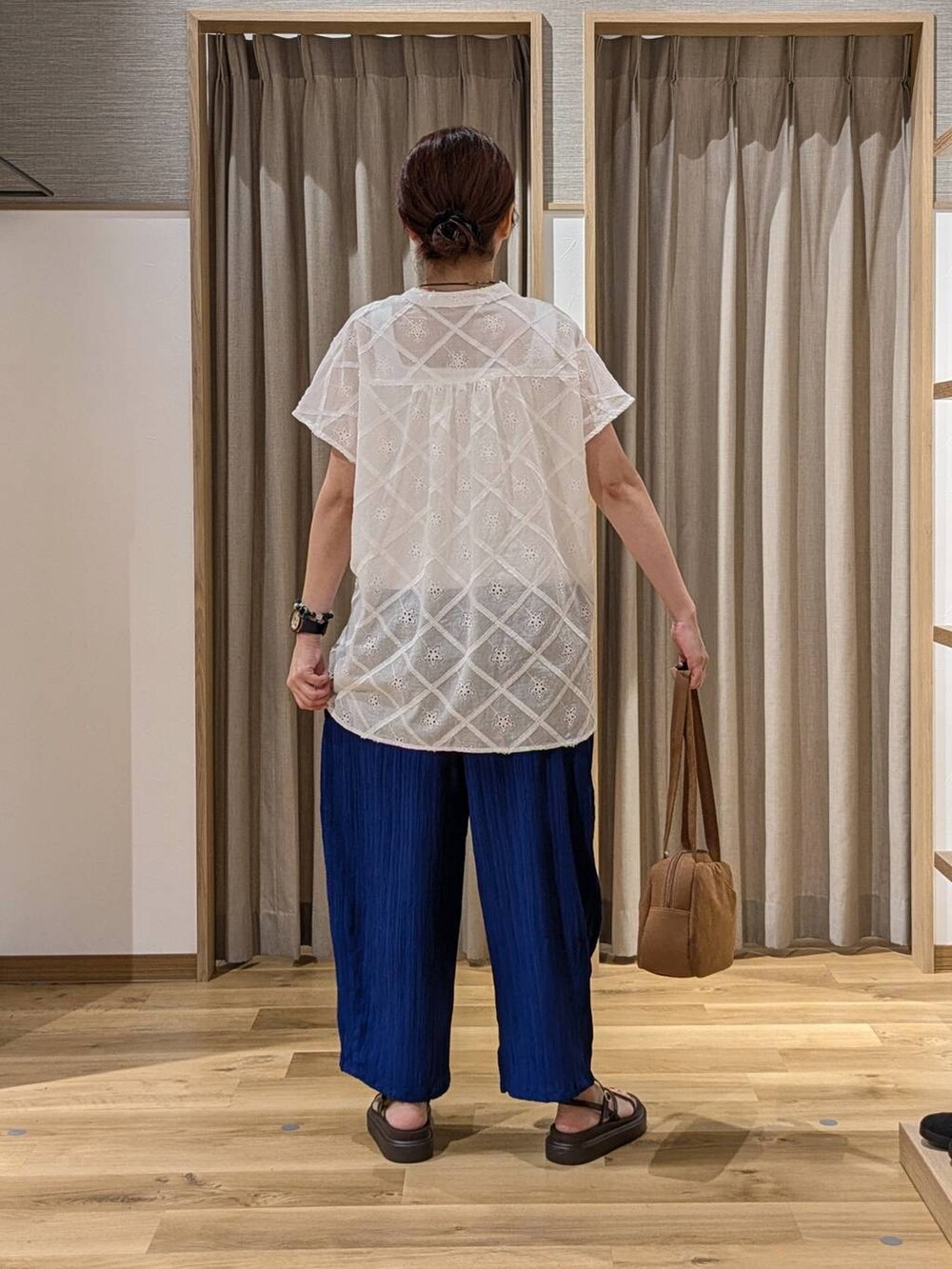 ブラウン系のショルダーバッグ、ブルー系のその他パンツ、ブラウン系のサンダルを着用したレディースの夏コーディネートの3枚目の写真