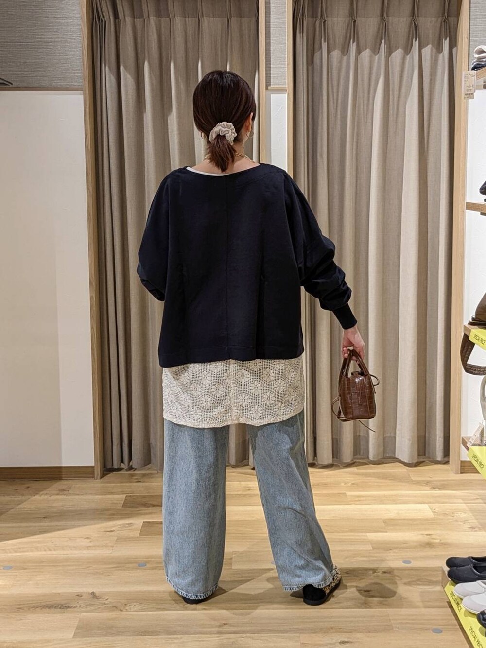 ブルー系のデニムパンツ、その他のスニーカー、ブラウン系のトートバッグを着用したレディースの春コーディネートの2枚目の写真