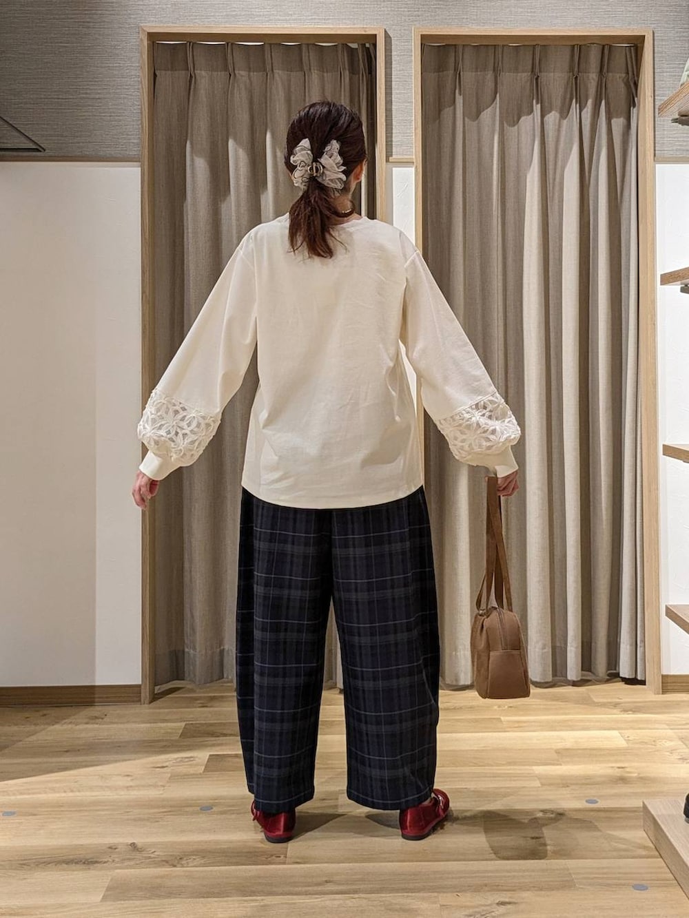 ブラウン系のショルダーバッグ、レッド系のその他シューズ、ホワイト系のTシャツ/カットソーを着用したレディースの秋コーディネートの3枚目の写真