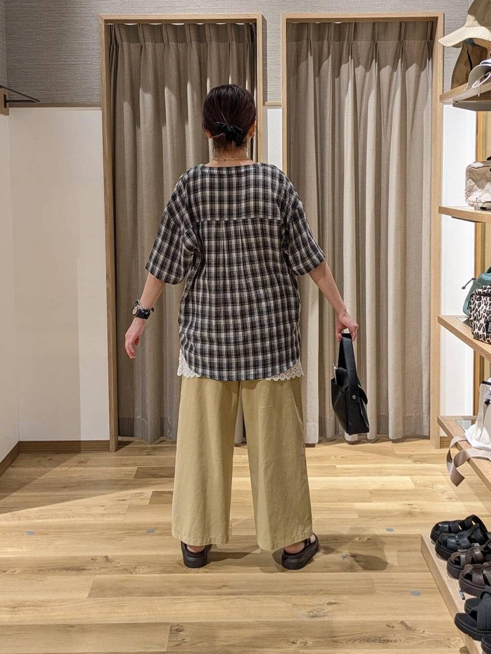 ブラウン系のサンダル、ベージュ系のその他パンツ、ブラック系のショルダーバッグを着用したレディースの夏コーディネートの2枚目の写真