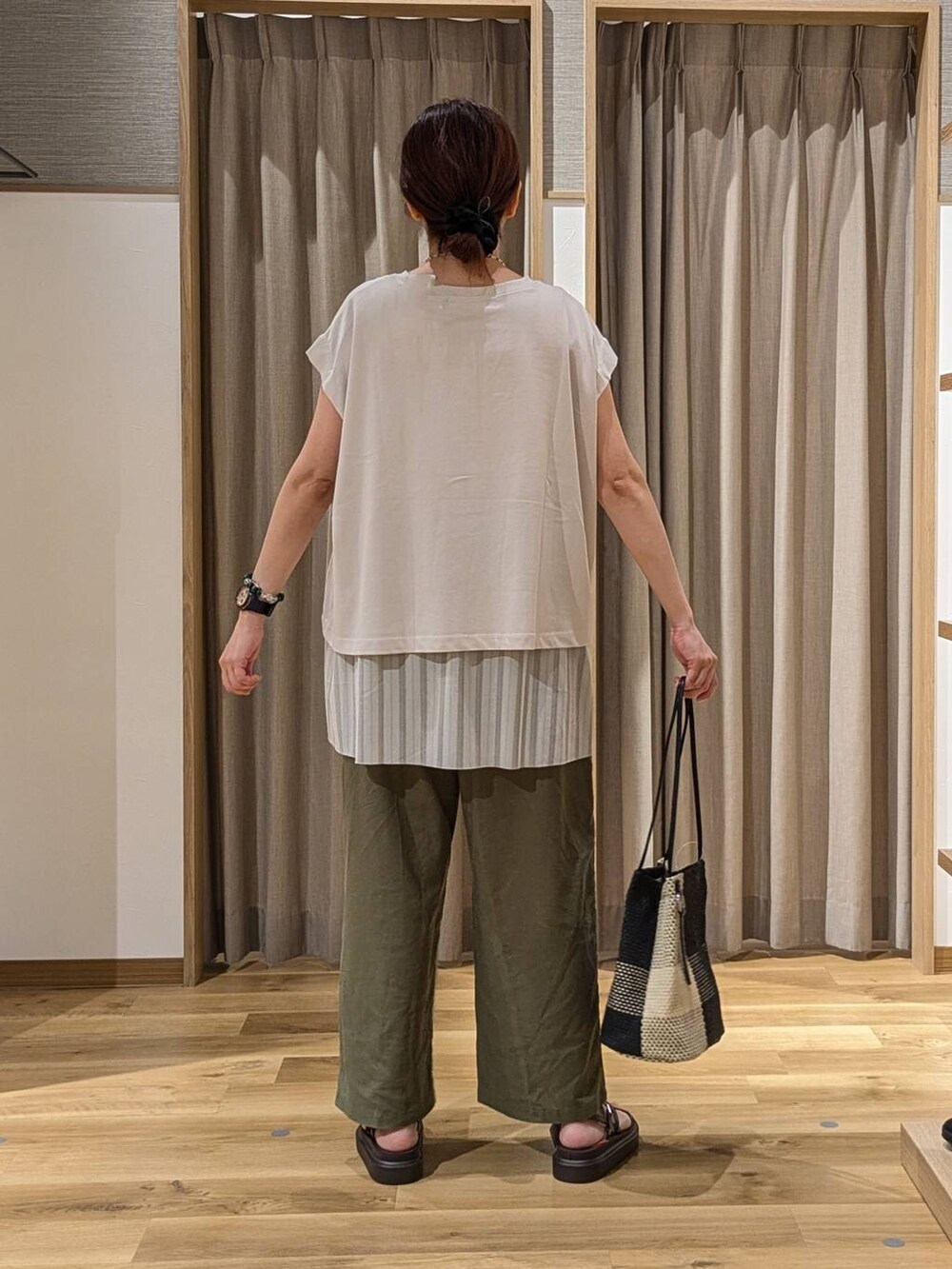 グレー系のTシャツ/カットソー、ブラック系のトートバッグ、ブラウン系のサンダルを着用したレディースの夏コーディネートの3枚目の写真