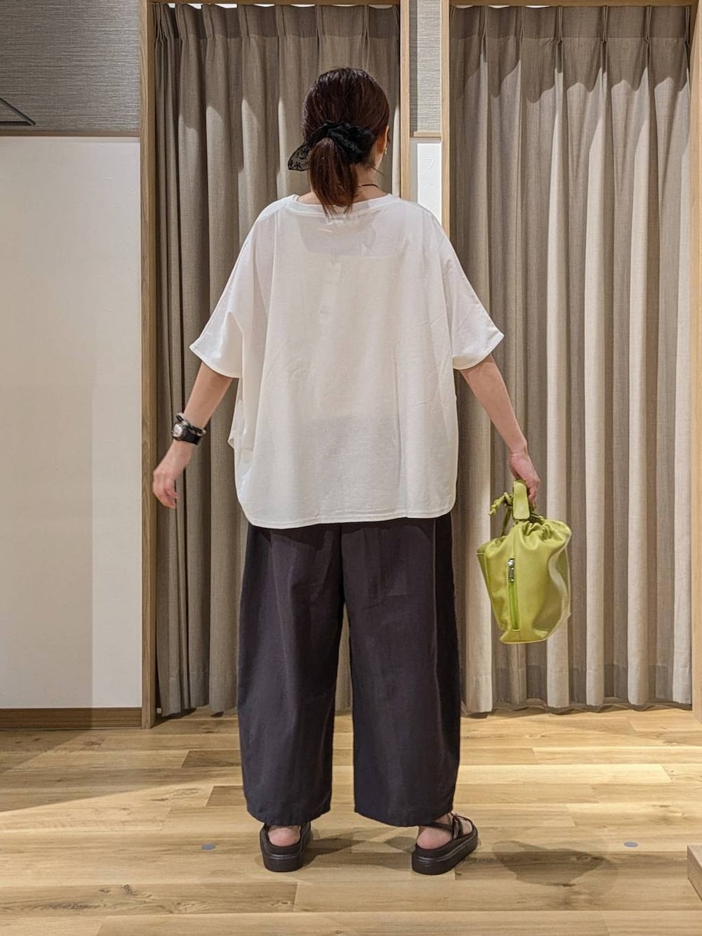 グリーン系のショルダーバッグ、ブラウン系のサンダル、その他のその他パンツを着用したレディースの夏コーディネートの3枚目の写真
