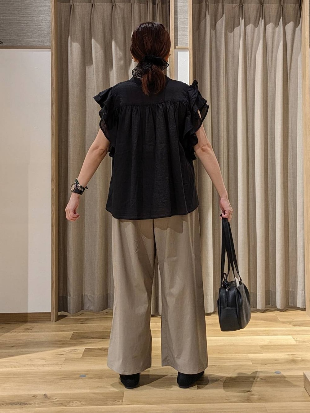 ブラック系のシャツ/ブラウス、ブラック系のショルダーバッグ、ブラック系のパンプスを着用したレディースの夏コーディネートの3枚目の写真