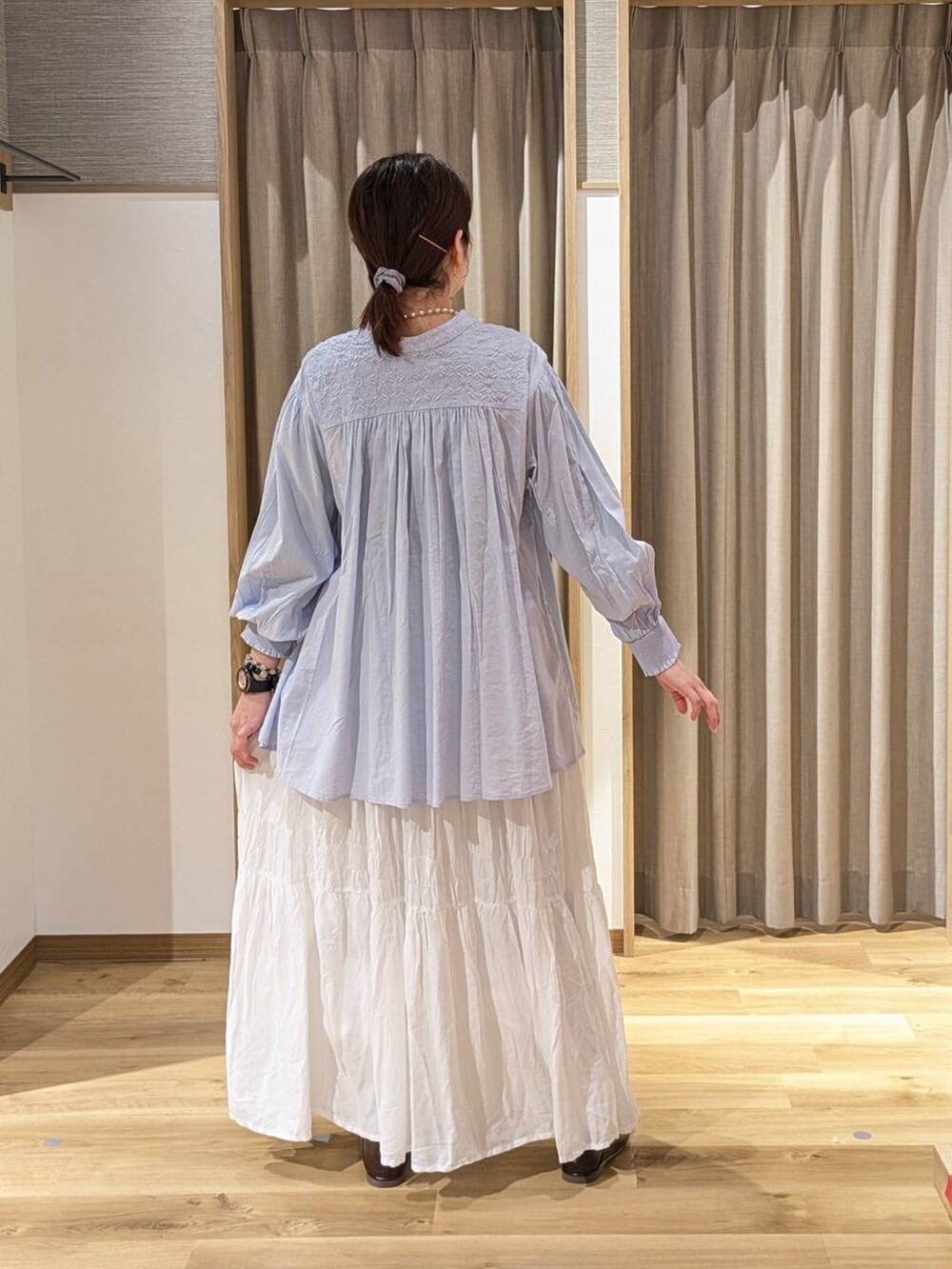 ホワイト系のスカート、ブラウン系のトートバッグ、ブラウン系のローファーを着用したレディースの冬コーディネートの2枚目の写真