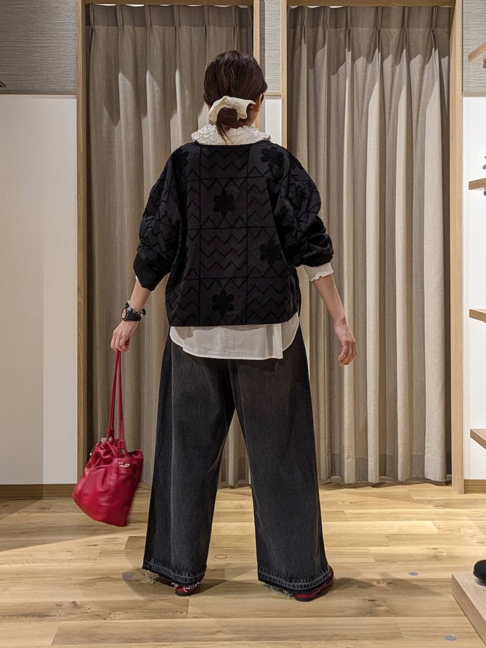 レッド系のその他シューズ、レッド系のショルダーバッグ、ブラウン系のデニムパンツを着用したレディースの秋コーディネートの3枚目の写真
