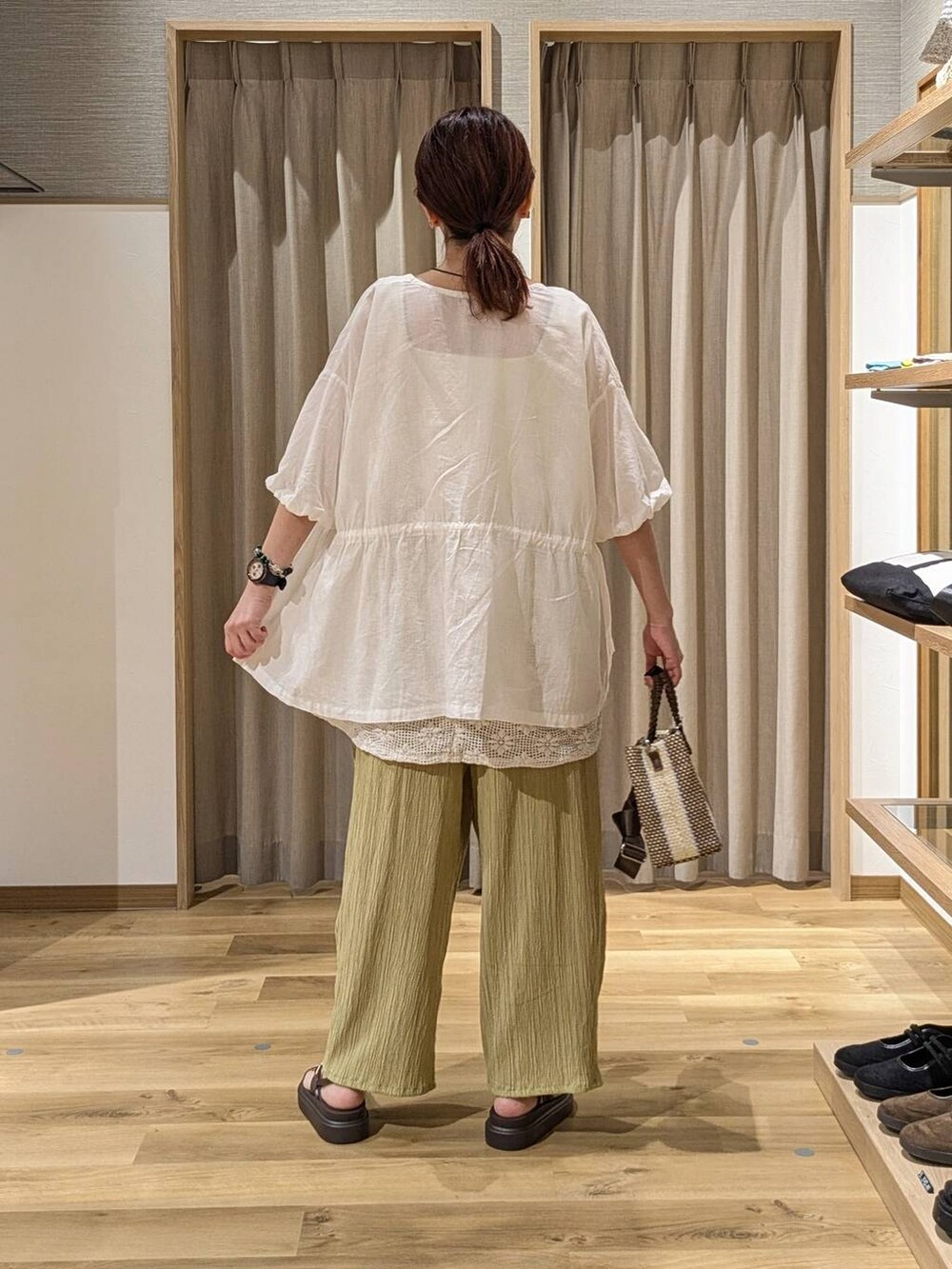 イエロー系のその他パンツ、ブルー系のショルダーバッグ、ブラウン系のサンダルを着用したレディースの夏コーディネートの3枚目の写真
