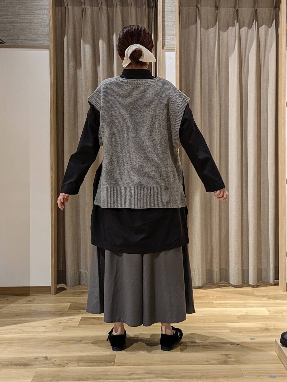 グレー系のチノパンツ、ブラック系のその他シューズ、ブラック系のショルダーバッグを着用したレディースの秋コーディネートの3枚目の写真