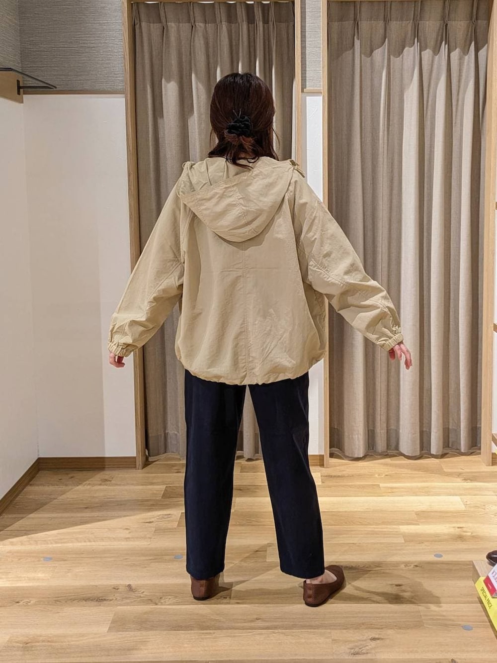 ベージュ系のマウンテンパーカー、ブラウン系のパンプス、ブラック系のトートバッグを着用したレディースの春コーディネートの2枚目の写真