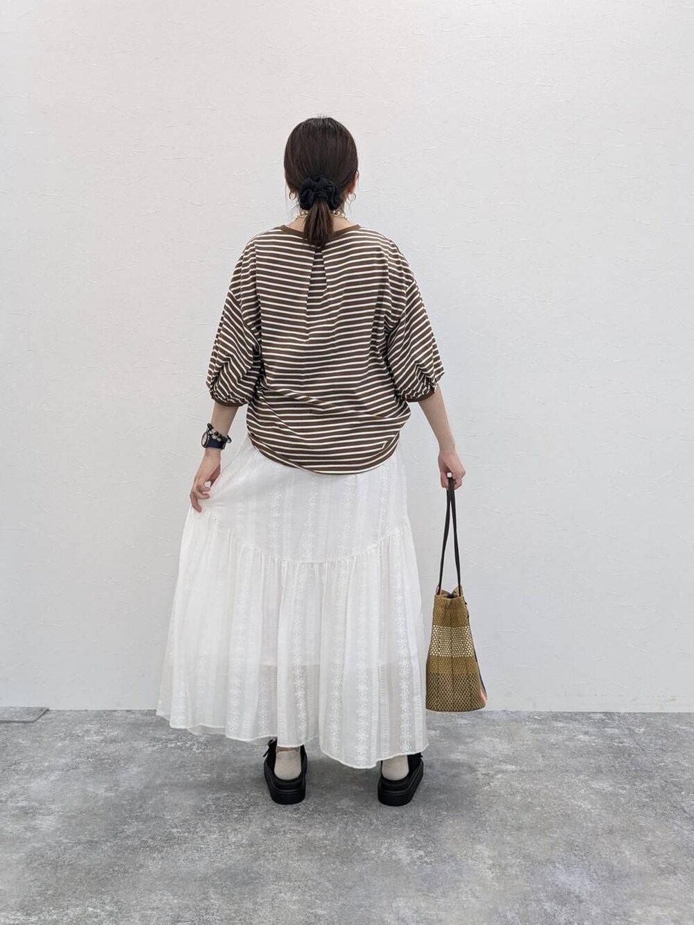 ブラック系のサンダル、ホワイト系のスカート、その他のTシャツ/カットソーを着用したレディースの春コーディネートの2枚目の写真