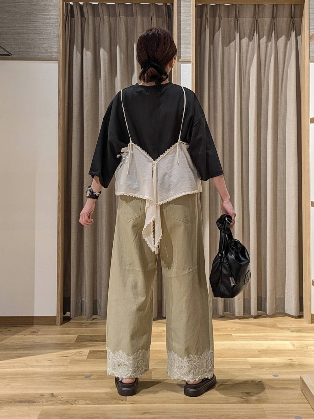 ベージュ系のデニムパンツ、ベージュ系のキャミソール、ブラウン系のサンダルを着用したレディースの夏コーディネートの3枚目の写真