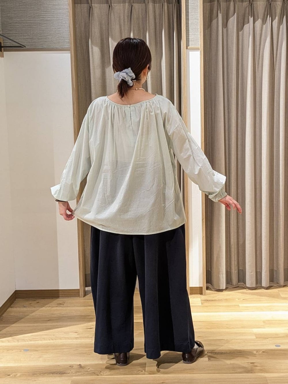 ブラウン系のショルダーバッグ、ブラウン系のローファー、ベージュ系のカーディガン/ボレロを着用したレディースの冬コーディネートの2枚目の写真