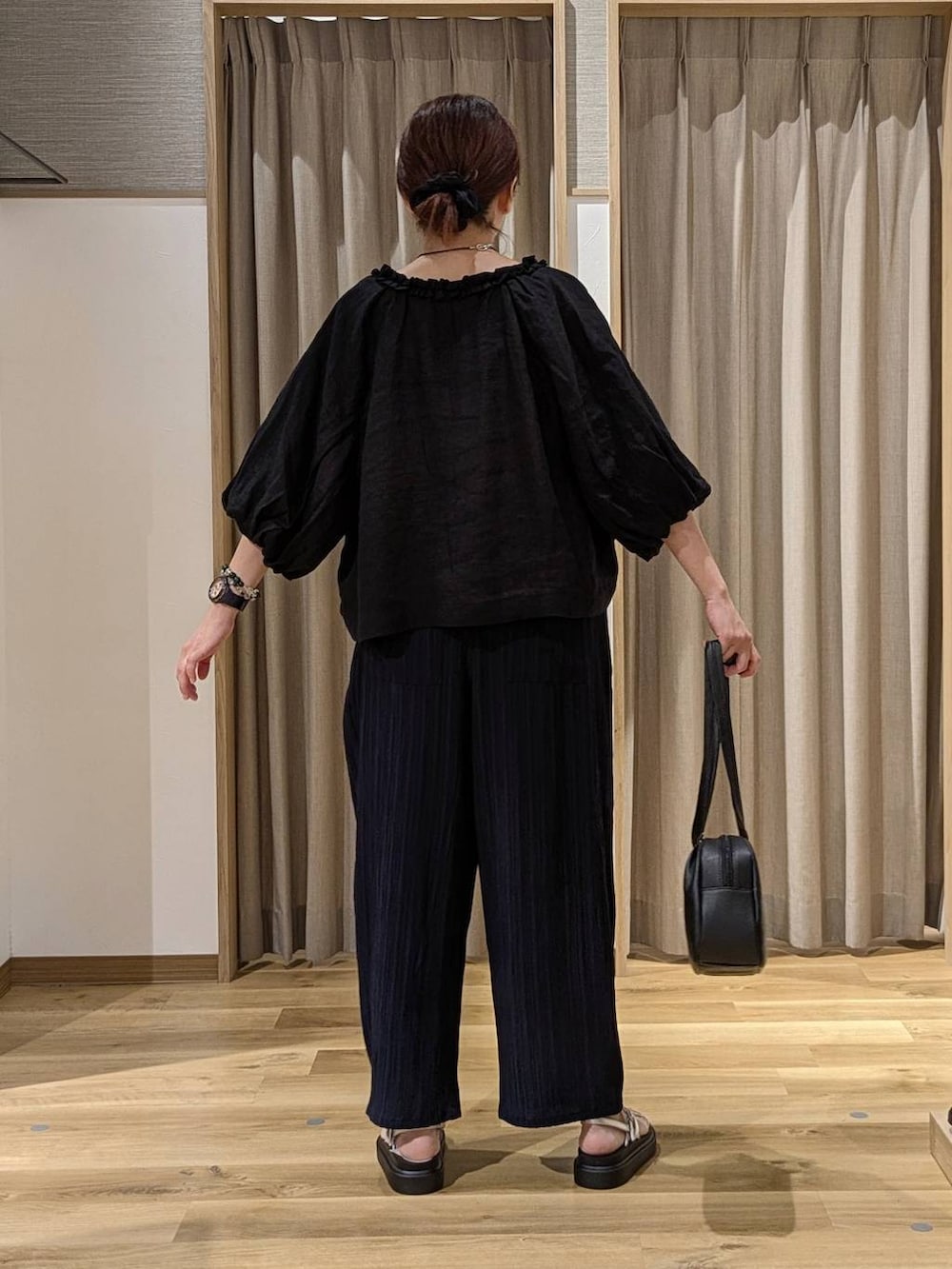 ブラック系のショルダーバッグ、ホワイト系のキャミソール、ブルー系のその他パンツを着用したレディースの夏コーディネートの3枚目の写真
