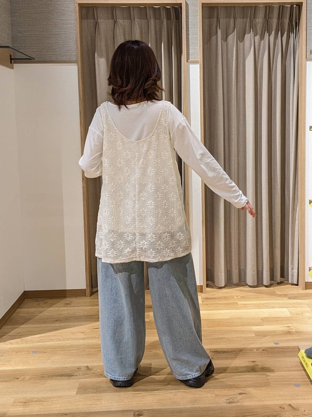 ブルー系のデニムパンツ、ブラック系のスニーカー、グリーン系のトートバッグを着用したレディースの冬コーディネートの3枚目の写真