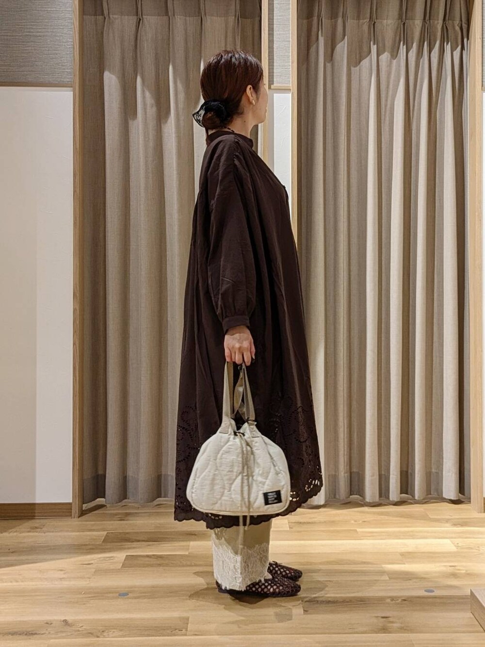 ベージュ系のデニムパンツ、ブラウン系のワンピース、ブラウン系のパンプスを着用したレディースの秋コーディネートの2枚目の写真