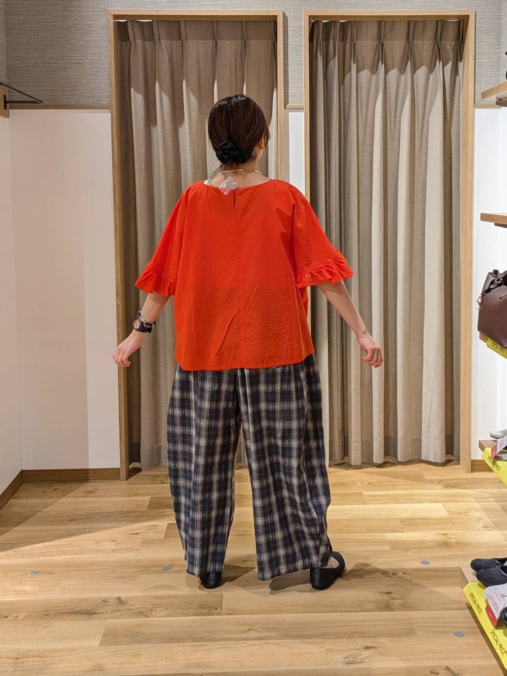 ブラック系のショルダーバッグ、グレー系のパンプス、オレンジ系のシャツ/ブラウスを着用したレディースの春コーディネートの2枚目の写真