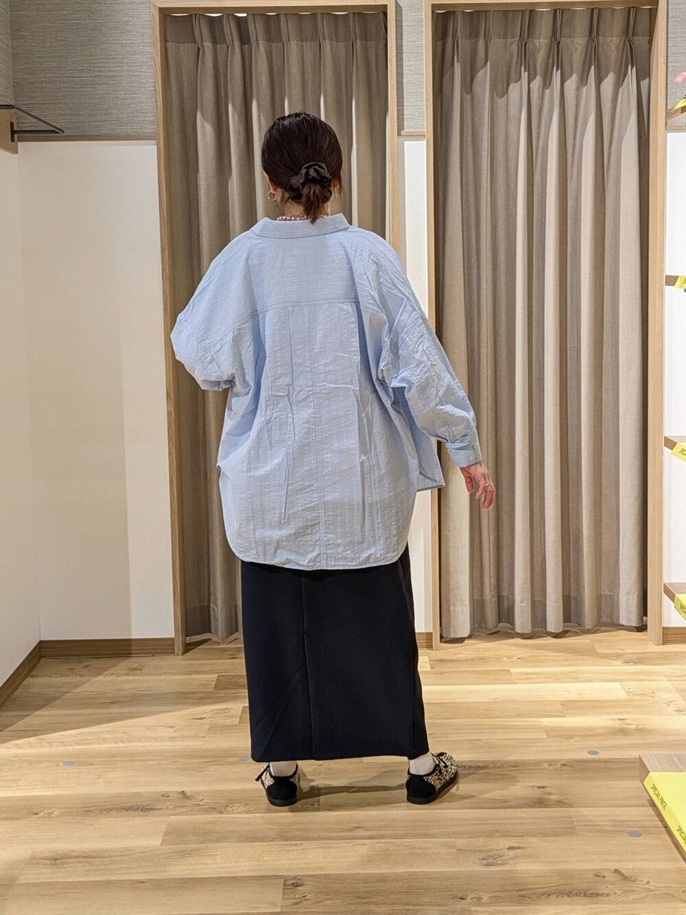 その他のスニーカー、ブルー系のスカート、ブラウン系のトートバッグを着用したレディースの冬コーディネートの3枚目の写真