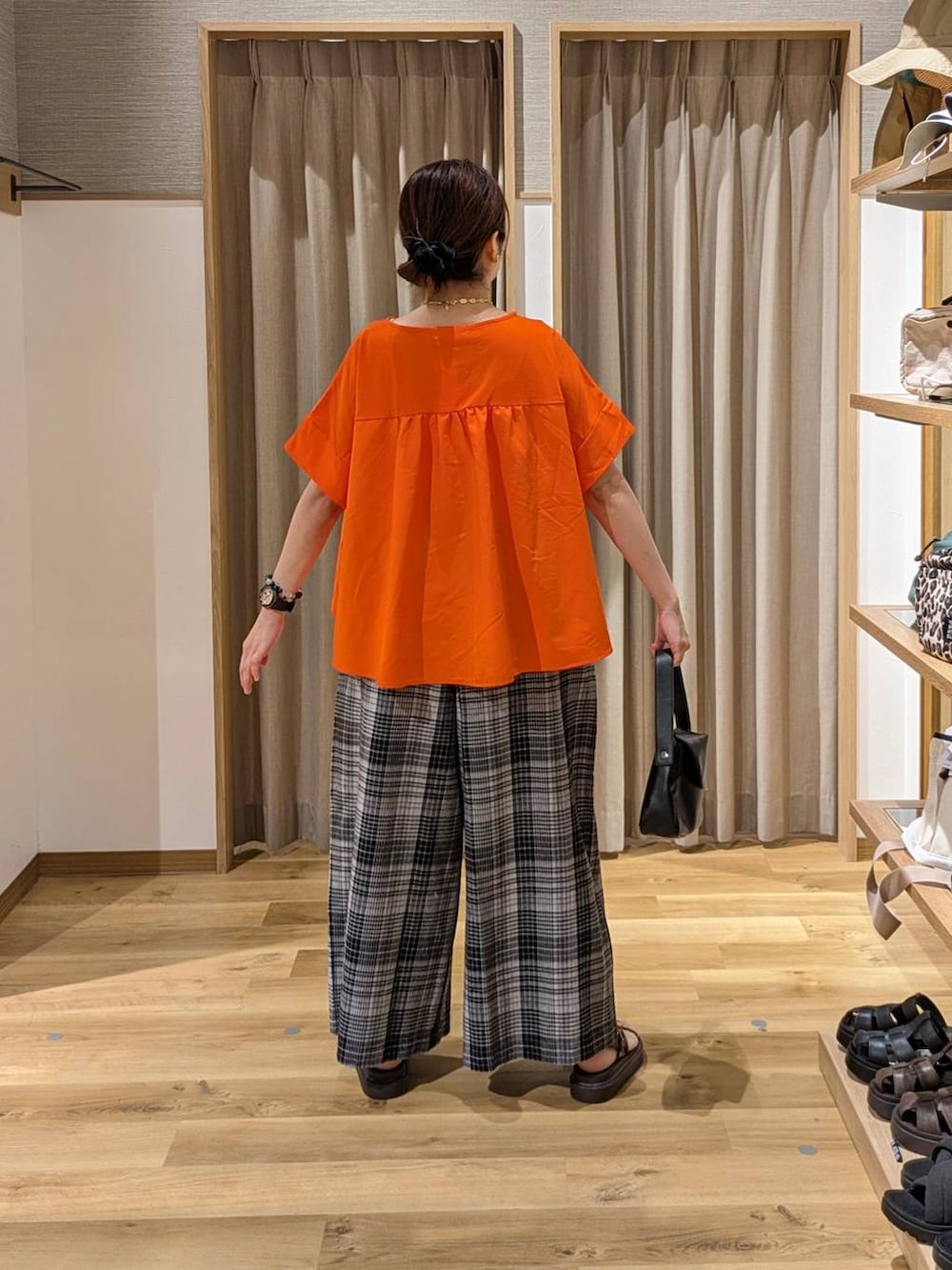 ブラウン系のサンダル、グレー系のその他パンツ、ブラック系のショルダーバッグを着用したレディースの夏コーディネートの2枚目の写真